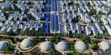 Aerial view of a modern urban area with dome-shaped structures and solar panels.