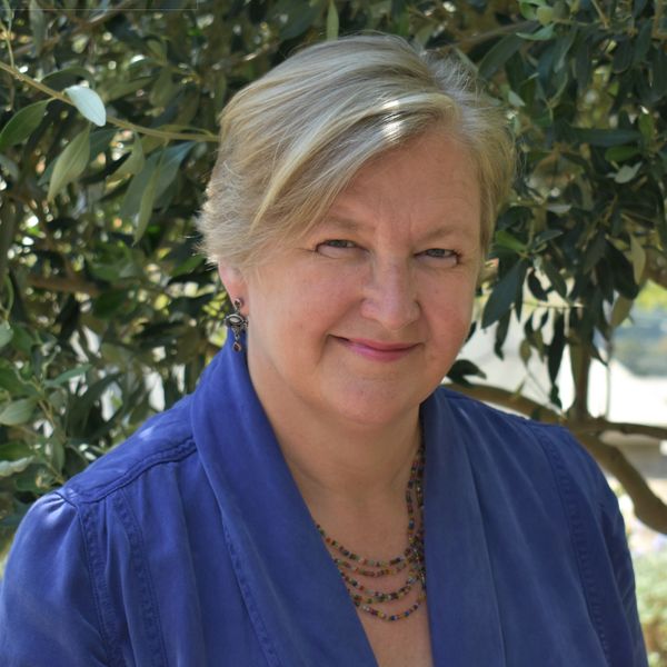 Portrait of Claire Haymes against olive tree background, translator, editor, copywriter 