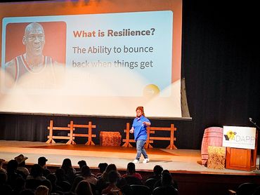 Speaker presents on resilience to an attentive audience in an auditorium.