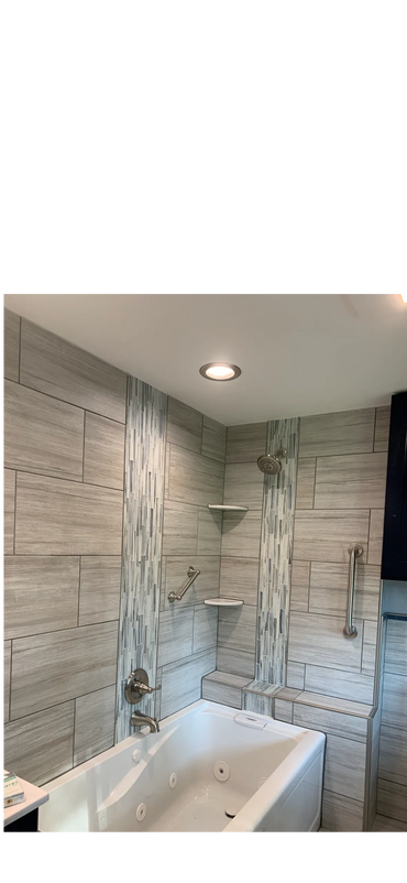 Modern bathroom with tiled walls and a white bathtub with jets.