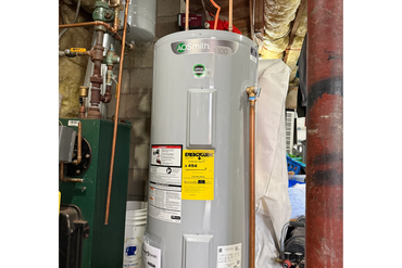 Technician inspecting a boiler and taking notes on a clipboard.