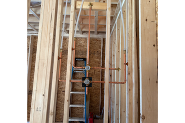 A technician in safety glasses and gloves fixing a boiler with a wrench.
