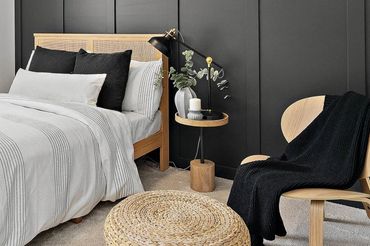 Black board and baton bedroom wall with blonde oak furnishings.