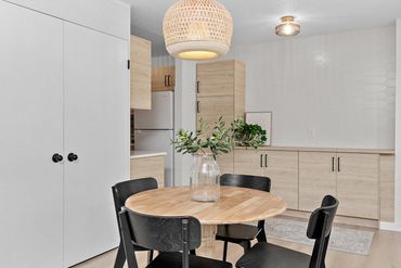 White picket Wall tile with white ash oak cabinetry in dining room.
