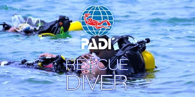 Two divers are submerged in water with PADI Rescue Diver logo overlay.