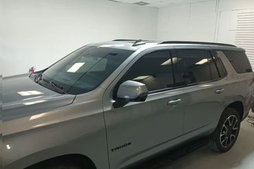 A silver Chevrolet Tahoe SUV parked indoors with tinted windows.