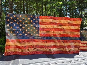 Wooden American flag art piece outdoors.