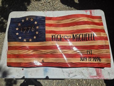 Wooden American flag with names and a date.