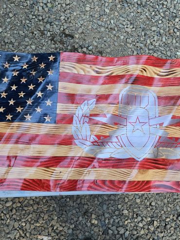 Wooden American flag with a bomb and laurel wreath design.