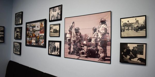 Wall with framed black and white photos of firefighters.