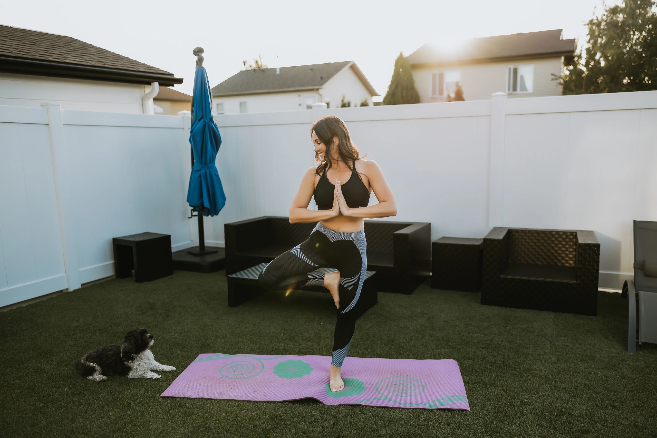 Annette Bruneau practicing yoga outside with her dog.