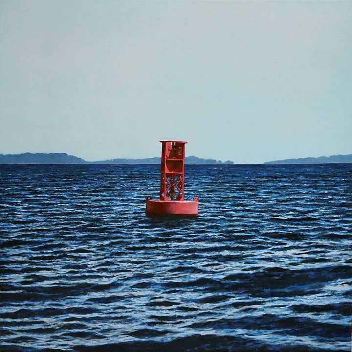 A red bell buoy on blue water, Camden Maine, blue islands in the distance, hazy blue sky