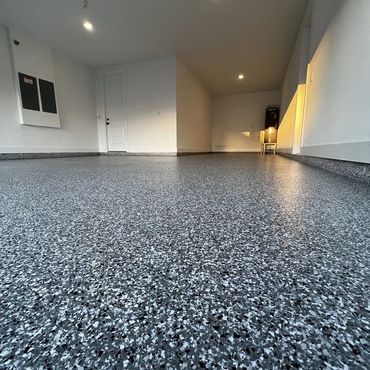 Clean, newly finished epoxy floor in a spacious empty garage.