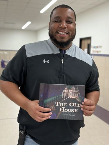 Smiling man holding a book titled 'The Old House' by Kenneth Maxwell.