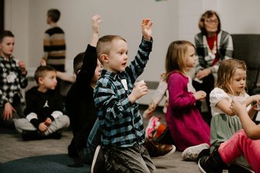 A little boy holds his hand up during Sunday School at Champion Life Church.