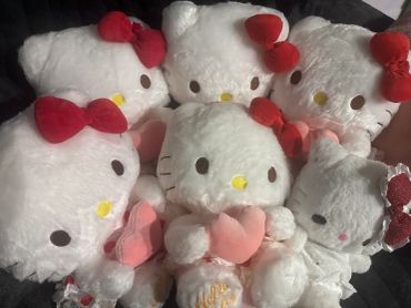 Group of Hello Kitty plush toys with red bows.