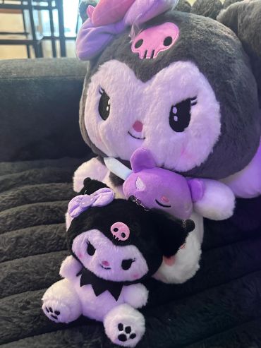Stacked plush toys with cute skulls and bows.