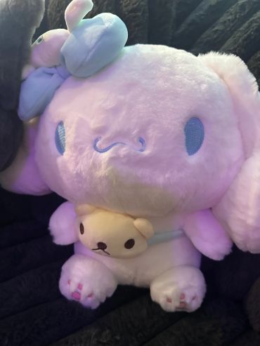 Fluffy stuffed toy with a big blue bow and a tiny bear.
