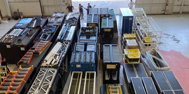 An organized warehouse with various large equipment and crates.