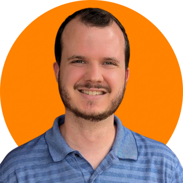 A smiling man in a blue striped polo shirt against an orange background.