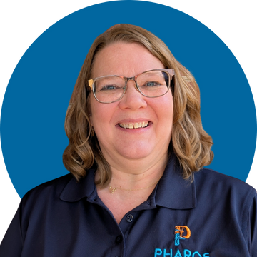 Smiling woman wearing glasses and a navy blue Pharos shirt.