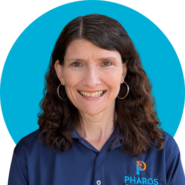 Smiling woman with curly hair in a blue Pharos shirt.