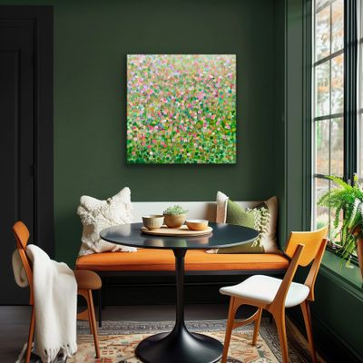 Cozy dining nook with green walls, orange seating, and vibrant floral artwork.