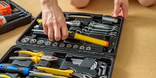 Person selecting a wrench from a tool kit.