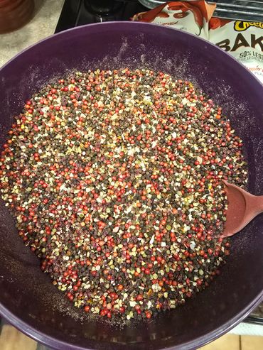 A large bowl filled with a colorful mix of peppercorns and spices.