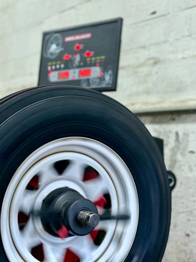 Close-up of a spinning car wheel on a tire balancing machine.