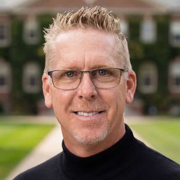 Smiling man with glasses and blond hair.