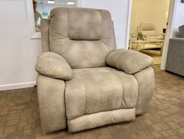 Plush beige recliner chair in a showroom setting.