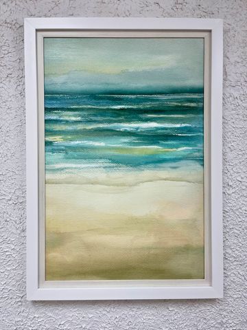 Framed watercolor painting of a serene seascape with waves and sandy beach.