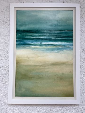 Framed watercolor painting of a serene beach with waves and sky.
