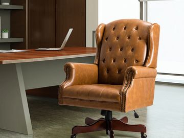 Brown leather office chair with tufted back and wooden base on wheels.