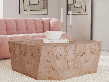 Modern living room with a pink tufted sofa and a textured stone coffee table.