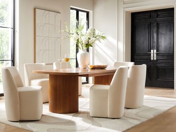 Elegant dining room with cream chairs, wooden table, and black double doors.