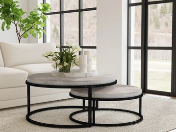 Modern living room with nested round coffee tables and large windows.
