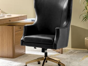 Black leather office chair with gold base and casters.