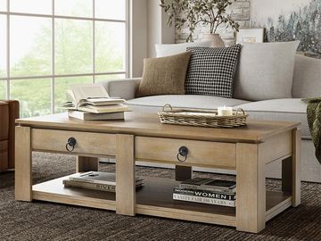 Wooden coffee table with books and decorative items in a cozy living room.