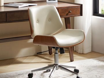 Modern office chair with cream upholstery and wooden frame on wheels.