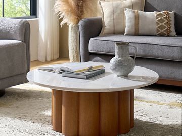 Modern living room with a round marble coffee table and gray sofas.