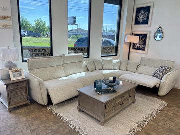 Modern living room with a large beige sectional sofa and wooden coffee table.