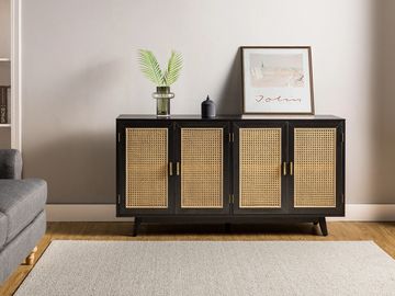 Modern black and rattan cabinet with decorative items on top.