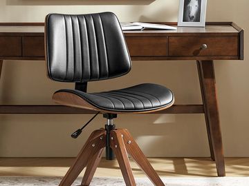 Black leather and wood office chair in front of a wooden desk.