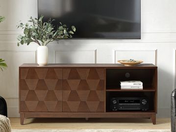 Modern wooden TV stand with geometric front panels and decorative items.