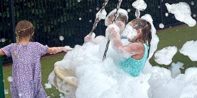 Group of kids enjoying a foam party experience with music and high-energy fun
