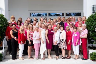 Large group of women posing outdoors in colorful attire.