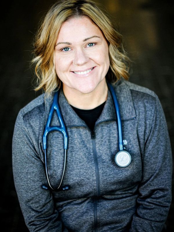 Smiling female healthcare professional with a stethoscope around her neck.