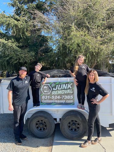 A family poses in front of a junk removal truck.